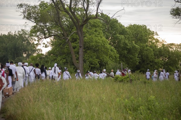 Detroit, Michigan - African-Americans gather on the banks of the Detroit River to commemorate ancestors lost in the slave trade. The annual event, known as The Carnival of the Spirit, is organized by the African Diaspora Ancestral Commemoration Institute