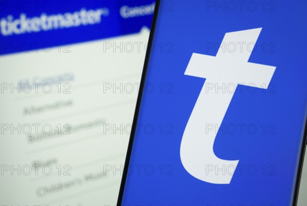 Dhaka, Bangladesh - 18 March 2025: The logo of the Ticketmaster is displayed on a smartphone screen, and the website Ticketmaster is visible on a computer screen in the background