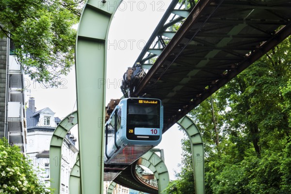 The Wuppertal suspension railway runs through Vohwinkel in front of buildings from the Wilhelminian era near the Hammerstein stop in Wuppertal, Germany