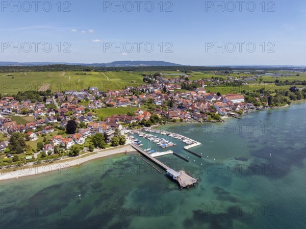 Luftbild von der Bodenseegemeinde Hagnau, Winzerdorf und beliebter Ferienort am Bodensee, dahinter Rebhänge, auf denen hauptsächlich die Weinsorten Müller Thurgau und Blauer Burgunder angebaut werden. Am Seeufer der am 23.Mai 2025 eingeweihte, neue Westhafen, Yachthafen mit der Schiffanlegestelle, Bodenseekreis, Baden-Württemberg, Deutschland