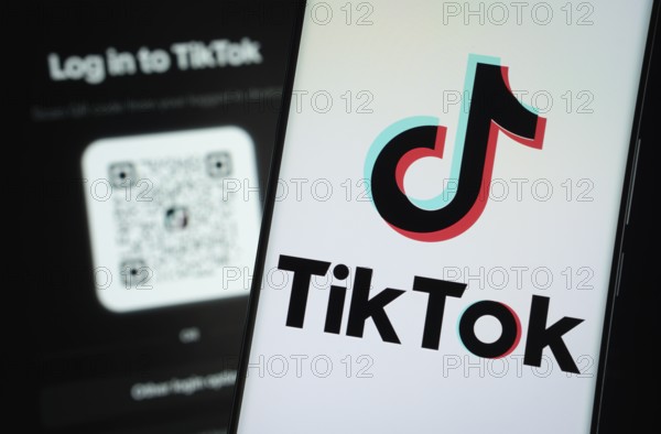 Dhaka, Bangladesh- 18 March 2025: tiktok logo is displayed on a smartphone screen, with the tiktok login page visible on a computer screen in the background