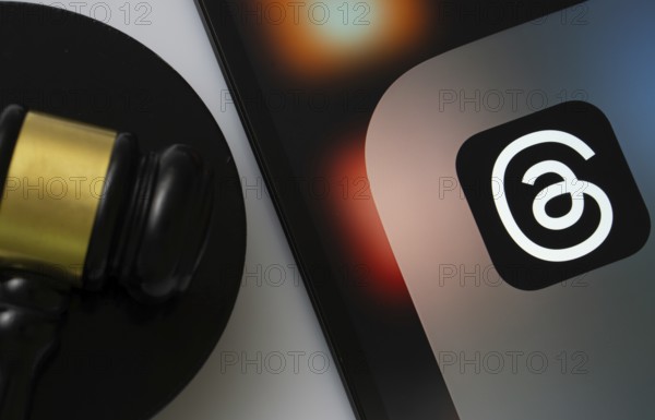 Dhaka, Bangladesh- 18 March 2025: A close up of an iPad screen displaying the threads app alongside a judge's gavel