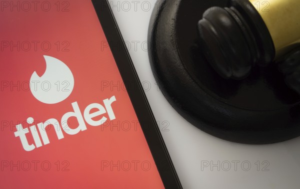 Dhaka, Bangladesh- 18 March 2025: A close up of an iPad screen displaying the tinder app alongside a judge's gavel