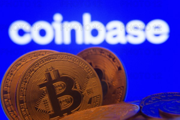 Dhaka, Bangladesh- 16 June 2025: Close-up of Bitcoin coins with the Coinbase logo visible on a screen in the background