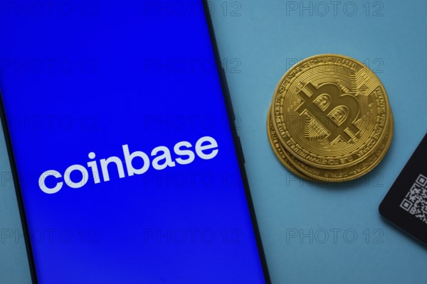 Dhaka, Bangladesh- 16 June 2025: Coinbase logo on smartphone screen near Bitcoin coin and QR code on blue background