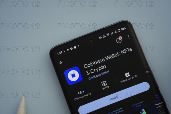Dhaka, Bangladesh- 29 May 2025: On a blue surface, a smartphone displays the Coinbase app within the Google Play Store