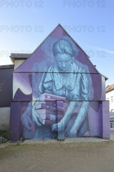 Mural Knowledge by Sokar Uno 2023, blue violet house wall, woman carrying a stack of books, books, reading, learning, view from below, street art, graffiti, double image, Weißenfels, Saxony-Anhalt, Germany