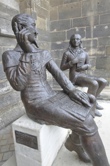 Sculpture Schütz-Novalis Bench by Steffen Ahrens and Grit Berkner 2022, composer Heinrich Schütz, writer Novalis Friedrich von Hardenberg, bench, monument, modern art, two, bronze sculptures, sitting, communication, interaction, pointing finger, listening, telling, talking, market square, Weißenfels, Saxony-Anhalt, Germany