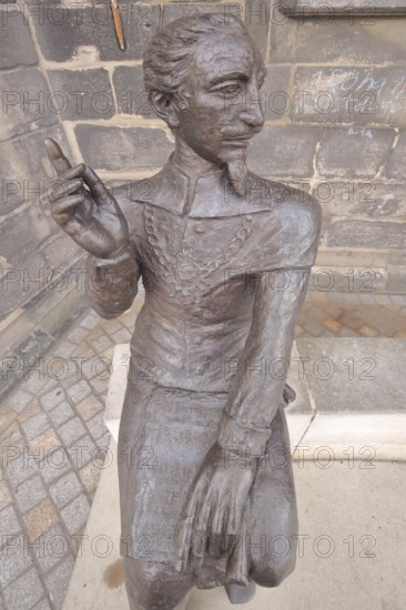 Sculpture Schütz-Novalis bench by Steffen Ahrens and Grit Berkner 2022, composer Heinrich Schütz, bench, monument, modern art, sitting, index finger, gesture, arm, high, above, market square, Weißenfels, Saxony-Anhalt, Germany
