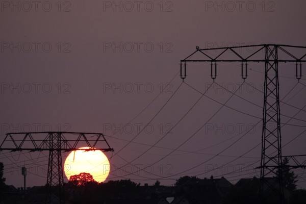 Transmission of energy with high-voltage lines, symbolic image for the energy transition, evening sun, Germany