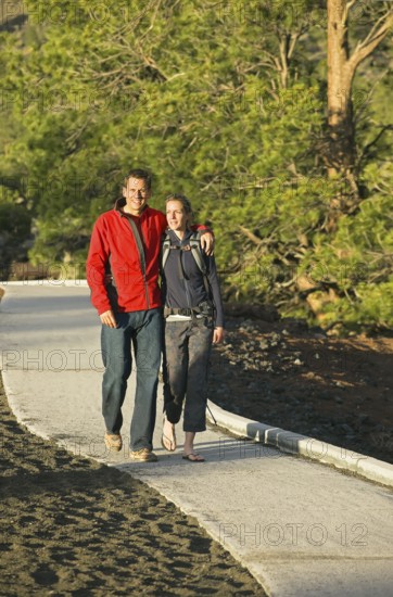 Couple walking on pathway, Sunset Crater Volcano National Monument, Flagstaff, Arizona, USA