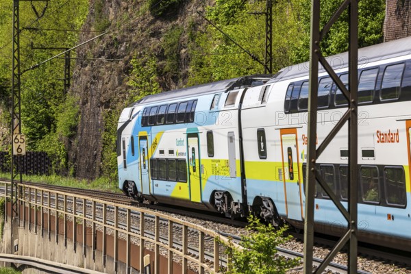 Train of the Austrian Westbahn en route on the winding railway line of the Geislinger Steige. Landscape on the railway's Filstalline line in spring. Amstetten, Baden-Württemberg, Germany