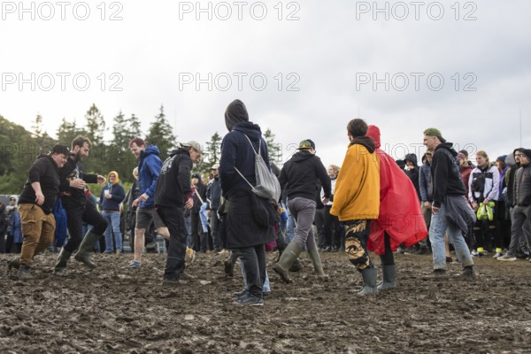 Festival visitors dance in the mud in front of the Atmos Stage at the Rock am Ring Festival on Sunday, Nürburgring race track race track, 08.06.2025