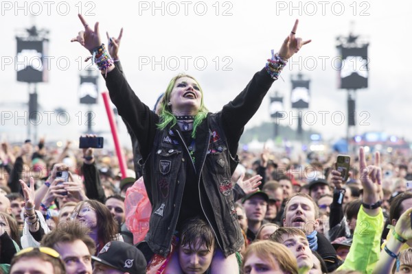Festival visitor on shoulders with a French fries fork shaped like a hand at the Rock am Ring Festival on Friday, Nürburgring race track race track, 07.06.2025