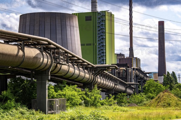 Pipelines for various gases, blast furnace gas, Thyssenkrupp Steel steelworks in Duisburg-Bruckhausen, in front the gas-fired Hamborn power station, green façade of boiler house Block5, North Rhine-Westphalia, Germany