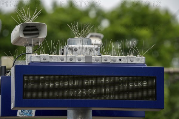 Display board, at a station, train cancellation announcement due to construction work, display shows text with apology for the train cancellation, peppered with thin wires against birds, pigeons, to keep the technical equipment free of bird droppings, bird defence, pigeon defence