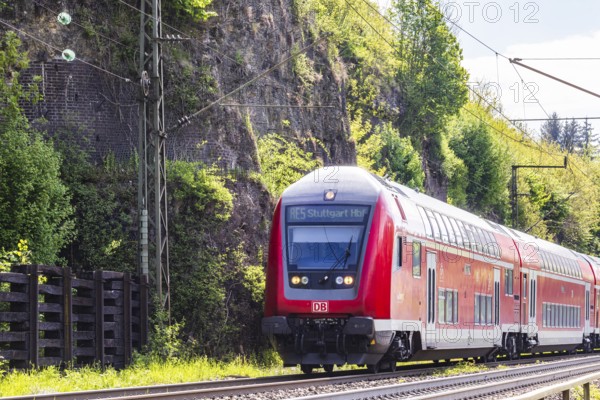 Regional express RE5 en route on the winding railway line of the Geislinger Steige. Landscape along the railway line in spring. Amstetten, Baden-Württemberg, Germany