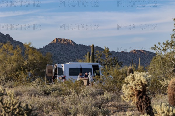 Camper van parked at a desert campsite at the White Tank Mountain Regional Park campground in Phoenix, Arizona, USA