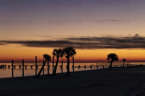 Sunset behind dilapidated fishing pier damaged by hurricanes on the Mississippi Gulf Coast in Long Beach, Mississippi
