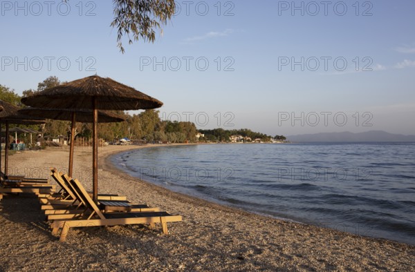 Sun loungers on the beach of Kala Nera at sunset on the Pagasitic Gulf, Pelion or Pelion Peninsula, Magnisia, Thessaly, Greece