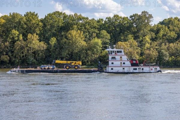 Tennessee Valley Authority tug boat Freedom pushing a barge with construction equipment upstream on the Tennessee River near Counce, Tennessee