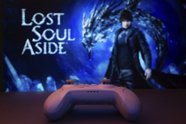 A game controller in focus with Lost Soul Aside screen in the background