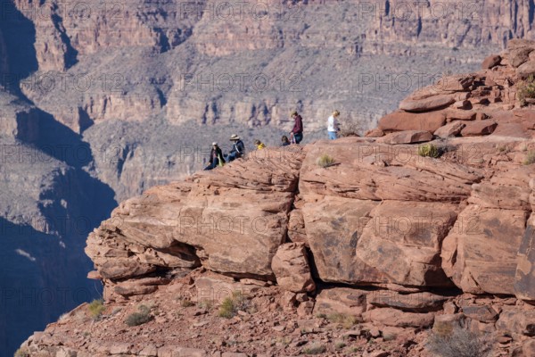 Visitors climb on rock formation rising above the canyon at Guano Point in Grand Canyon West near Peach Springs, Arizona