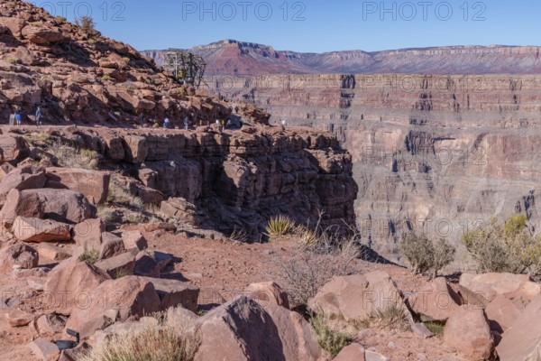 Visitors walk along the canyon rim to the location of the old mining cable structure at Guano Point in Grand Canyon West near Peach Springs, Arizona