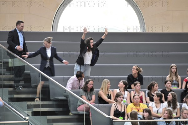 During the questioning of Foreign Minister Wadephul (CDU) on the Middle East, Israel and Gaza, a member of the audience shouts loudly from the bench, criticising the government. She is then escorted out of the chamber by the Bundestag police