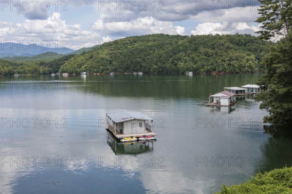 View of a house boats on Fontana Lake as seen from the open air car of the Great Smoky Mountains Railroad on its excursion from Bryson City, North Carolina