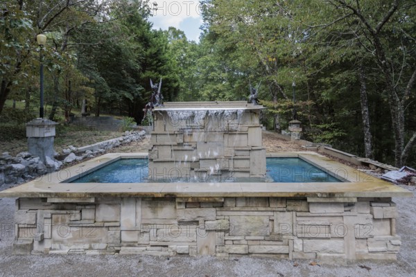 Water fountain with fairies and a sign reading Don't piss off the fairies near the entrance to Dismals Canyon near Phil Campbell, Alabama, USA