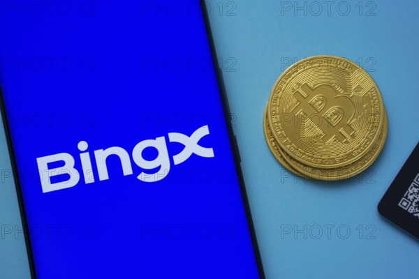 BingX logo on smartphone screen near Bitcoin coin and QR code on blue background