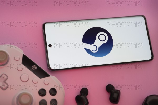 Smartphone with Steam logo, game controller, and earbuds on a pink background