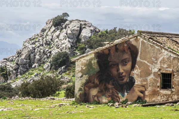 Large portrait painting on the wall of a house, typical rock formation in the back, El Torcal de Antequera, Sierra del Torcal, Antequera, Málaga, Andalusia, Spain