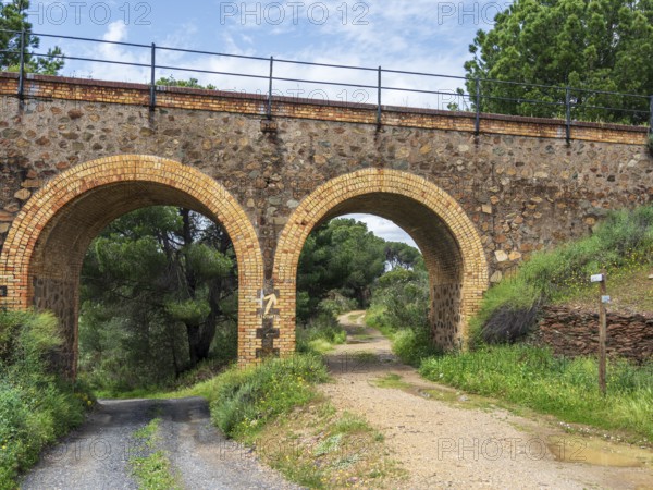 Cycle path via verde de Riotinto, on old railroad bridge, signpost to village Minas de Rio Tinto, Andalusia, Spain
