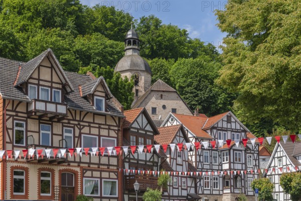Half-timbered idyll of the old town of Bad Sooden, Allendorf, district Bad Sooden, townscape with Protestant St. Mary's Church, tower clock, forest, restored half-timbered houses, gabled houses, hillside location, pennant, blue sky, clouds, Werra-Meissner district, Hesse, Germany