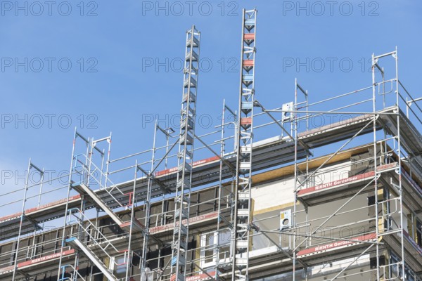 Symbolic image, residential construction, new building, corner building with extensive scaffolding, construction industry, trade, clear sky, Baden-Württemberg, Germany