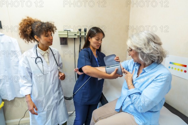 Nurse taking blood pressure of elderly woman during medical check up, supervised by doctor, promoting healthcare and senior patient care