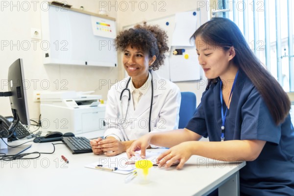 Two female doctors are reviewing a medical chart together, demonstrating teamwork and expertise in healthcare