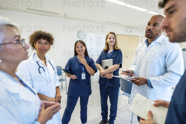 Doctors and nurses engaging in a collaborative discussion during a meeting at the hospital, sharing insights on patient care and treatment strategies