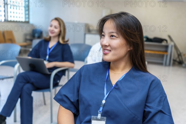 Young asian female nurse smiling during medical training in hospital conference room, healthcare professionals attending seminar