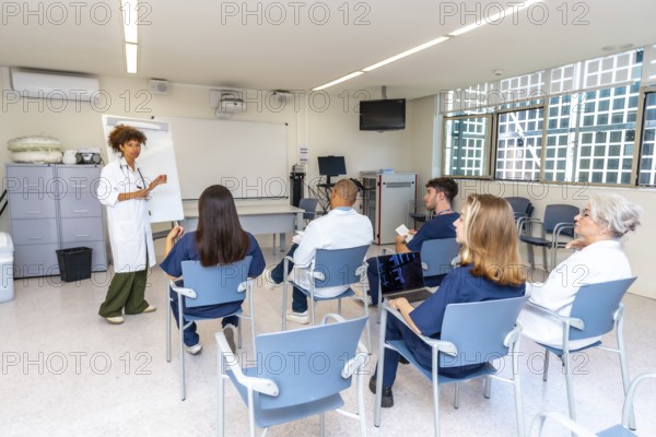 Diverse medical professionals attending a presentation held by a female doctor in a modern hospital meeting room