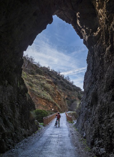 Cyclist on the Tranvía de Sierra Nevada, former railroad track, leading to the trail Vereda de la Estrella, Sierra Nevada, Andalusia, Spain