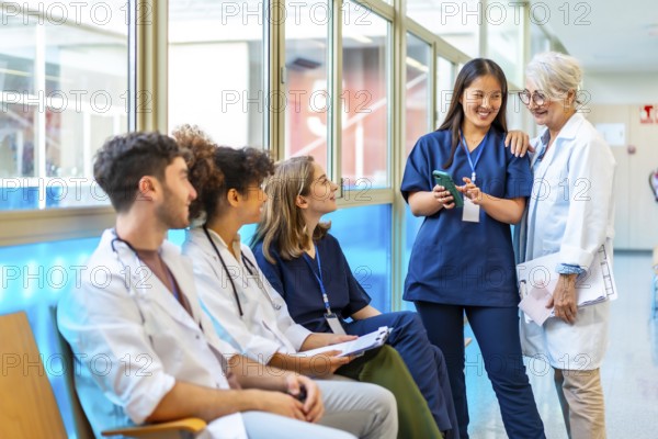 Doctors and nurses reviewing medical records on a smartphone, fostering collaboration and communication in a hospital setting