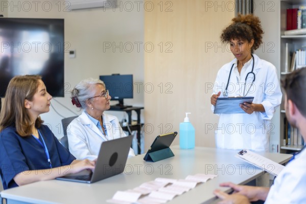 Doctors and nurses participating in a medical briefing, analyzing patient data and treatment plans in a modern hospital setting