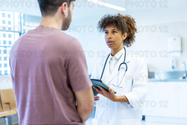 Doctor holding a tablet while explaining a diagnosis to a patient in a bright, modern hospital setting, fostering open communication and trust