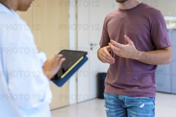 Medical professional using digital tablet while consulting with patient, enhancing healthcare communication and diagnosis