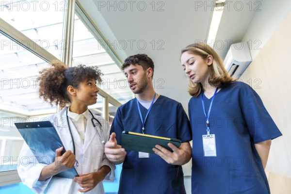 Doctors and nurses examining medical records and x rays, collaborating on patient care in a hospital hallway