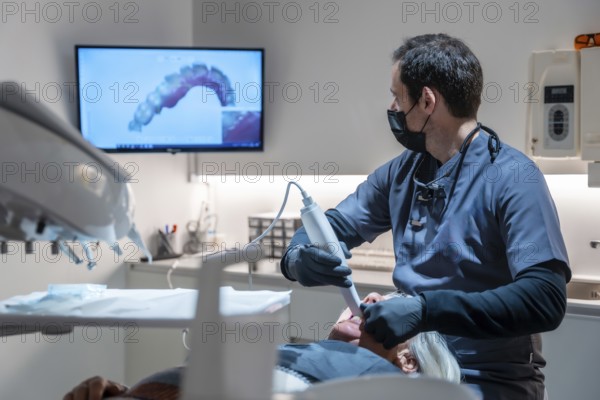 Dentist using an intraoral scanner for 3d scanning of teeth, creating precise digital models for diagnosis and treatment planning