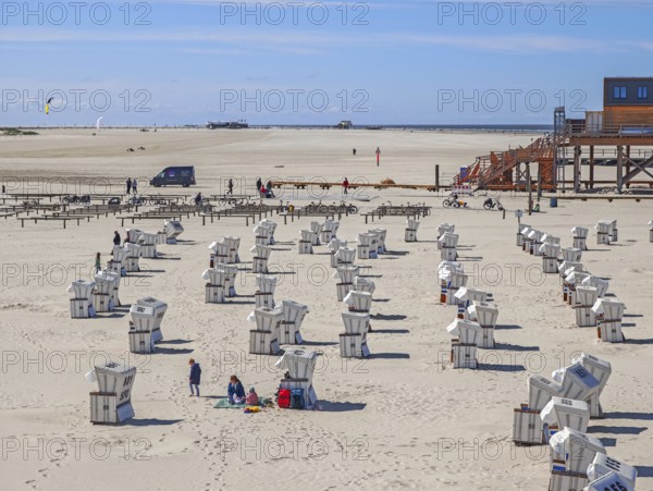 Preparing for the high season on the beach, first guests on the beach, setting up the beach chairs, North Sea, on the edge of the Wadden Sea National Park and UNESCO World Heritage Site, pile dwellings, kite buggy, sunshine and blue sky, SPO, Sankt Peter-Ording, Schleswig-Holstein, Germany